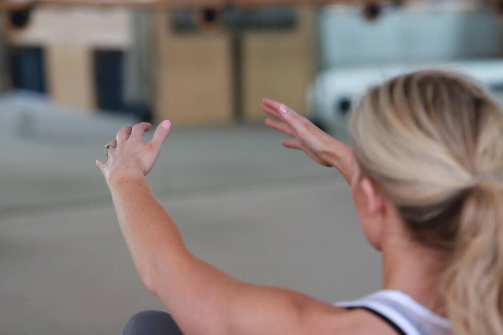 A woman with her arms outstretched doing a workout routine