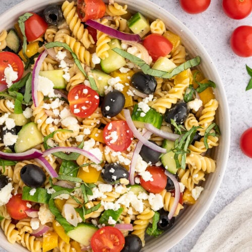 balsamic pasta salad filled with veggies in a white bowl