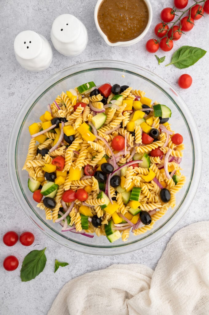 a glass bowl filled with ingredients for balsamic pasta salad before the balsamic dressing is added in