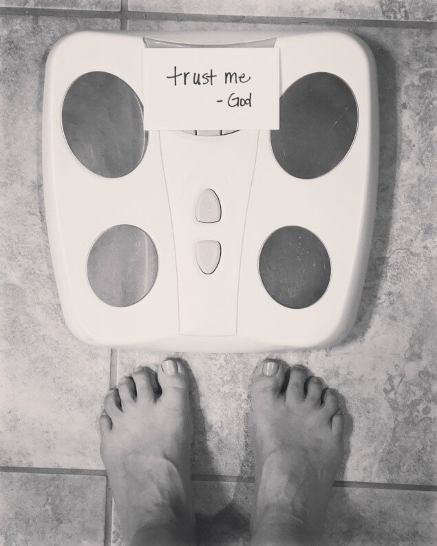 black and white photo of a scale with trust me god written over the number