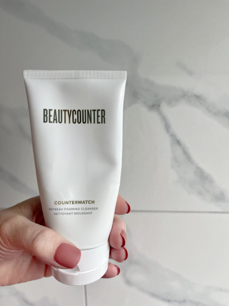 a woman holding a bottle of beauty counter countermatch face wash