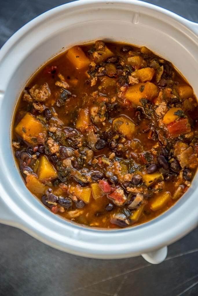 Slow Cooker Turkey Black Bean Chili and Butternut squash in a crockpot, overhead view.