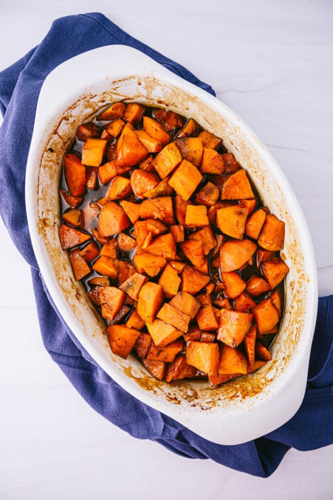 a white baking dish filled with candied sweet potatoes 