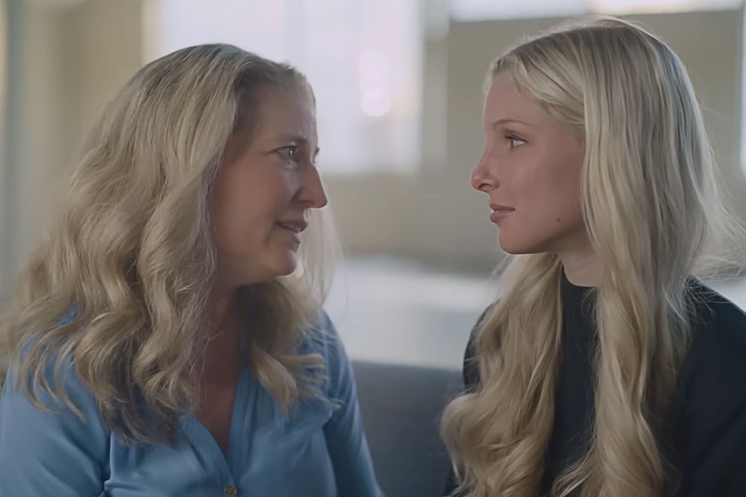 An image of a young girl sitting down and facing her mother as part of a campaign for the Dove Self-Esteem Project