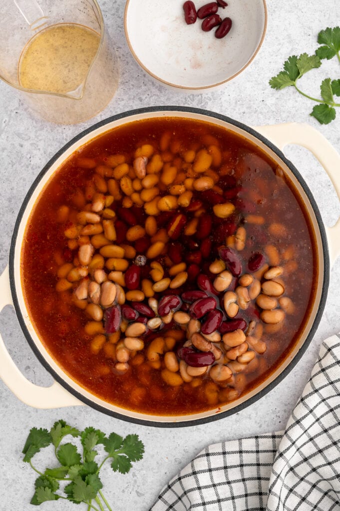 beans that have been added into a dutch oven for dutch oven chili