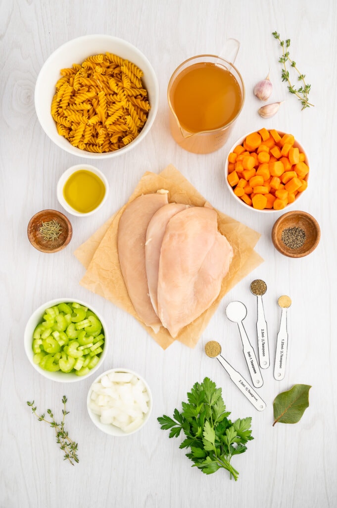 an overhead view of the ingrdients needed for gluten free chicken noodle soup