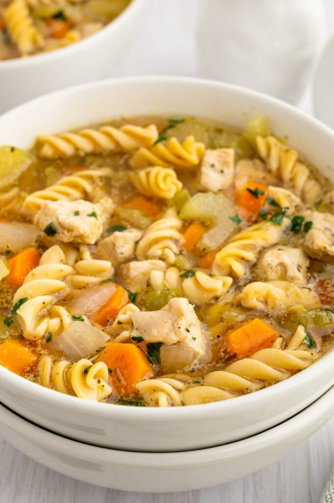 an up close picture of a bowl of gluten free chicken noodle soup