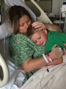 Son hugging his mom in a hospital bed