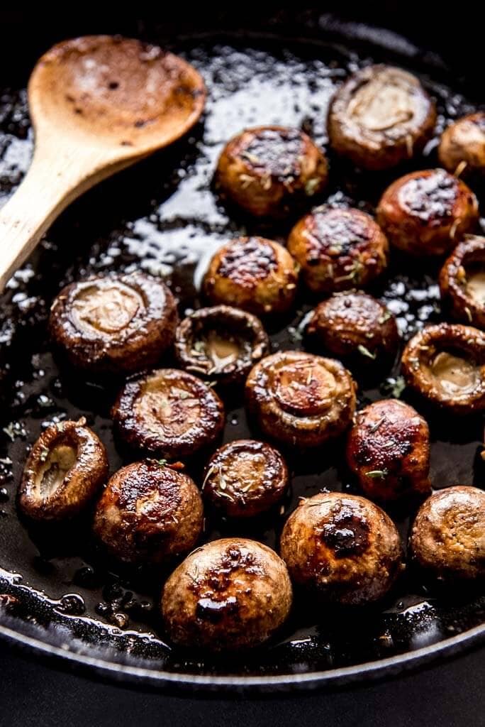 Sautéed mushrooms with a wooden spoon