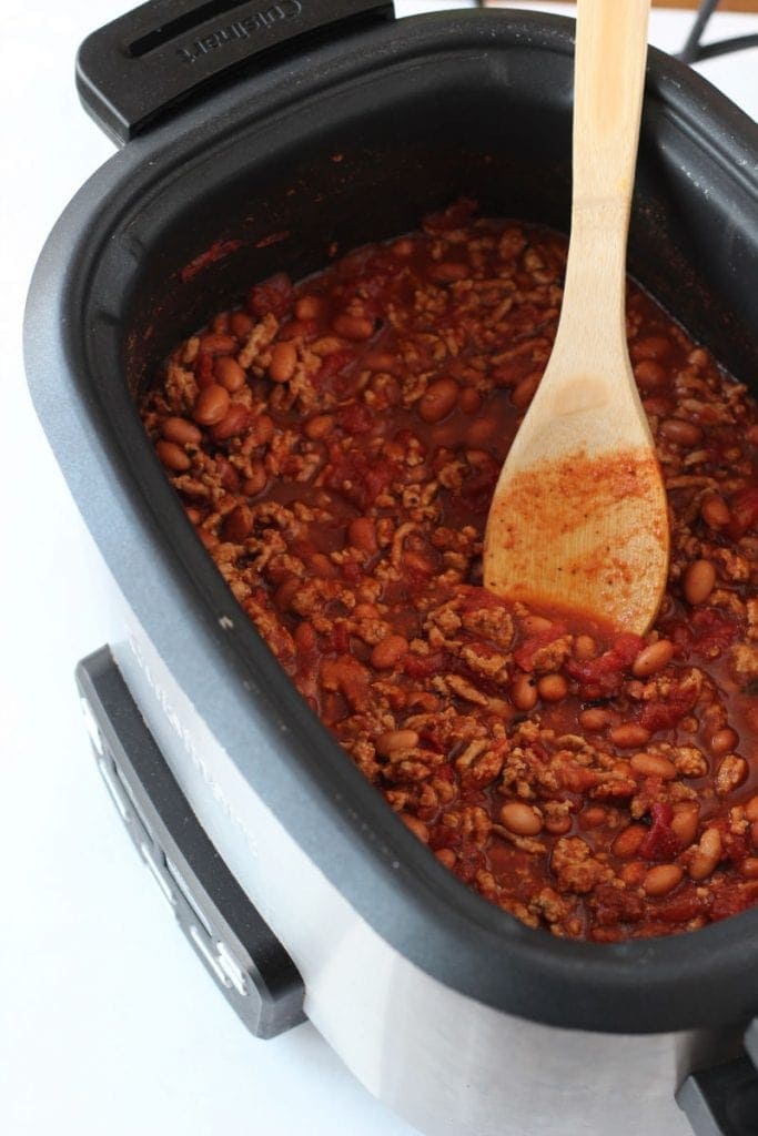 Slow Cooker Turkey Chili in a slow cooker with a wooden spoon.