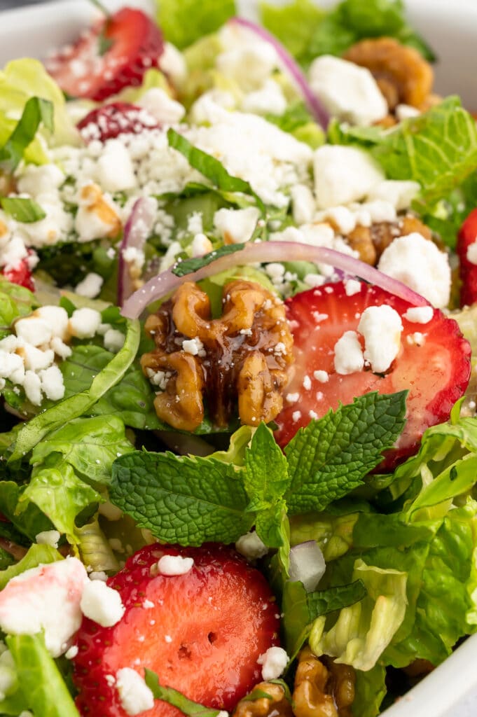 close up of strawberry goat cheese salad with a candied walnut
