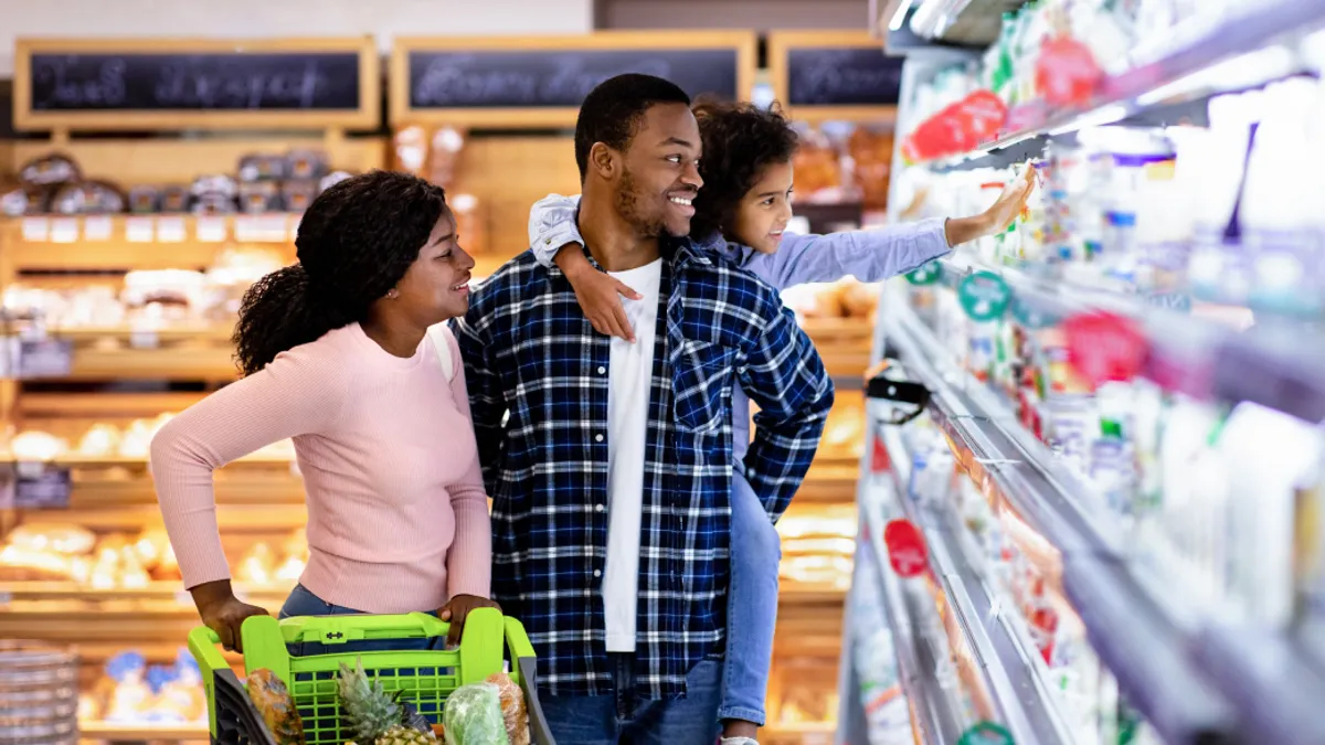 Happy family with shopping cart together at grocery store.