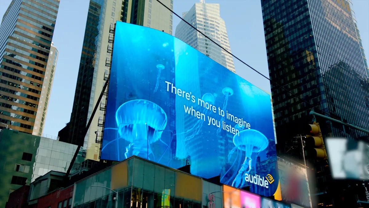 Audible's AR OOH campaign on a screen in New York. The image reads, "There's more to imagine when you listen."