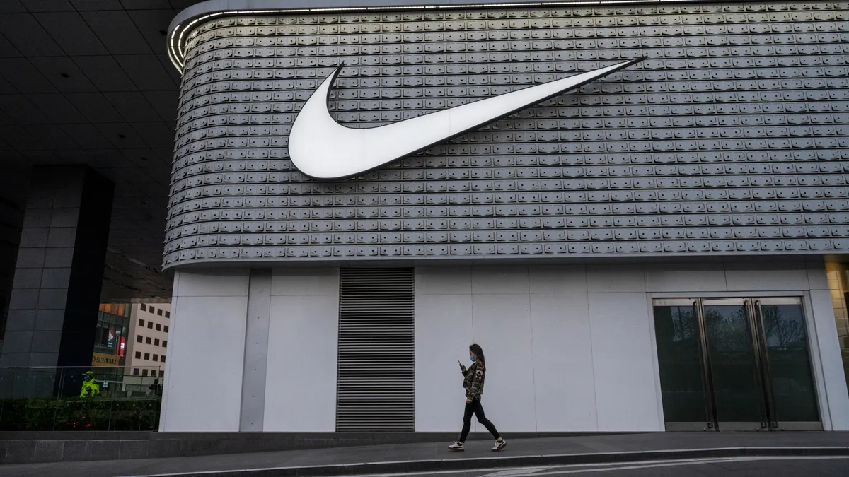 A person walks in front of a Nike store.