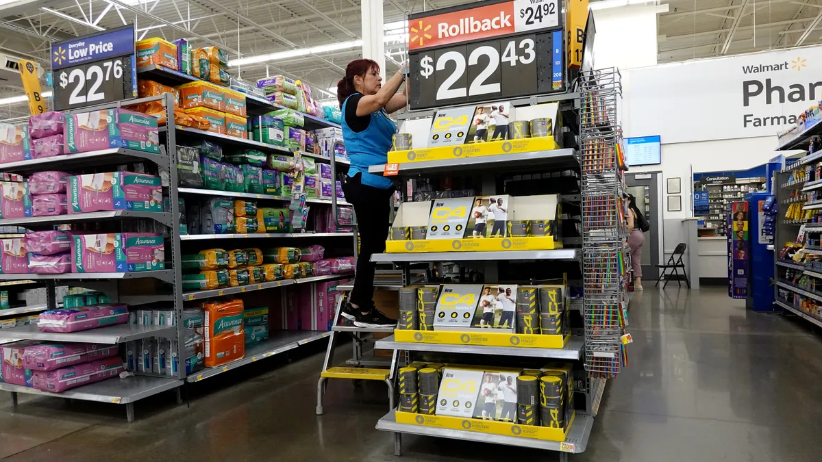 A Walmart associate stocks a shelf