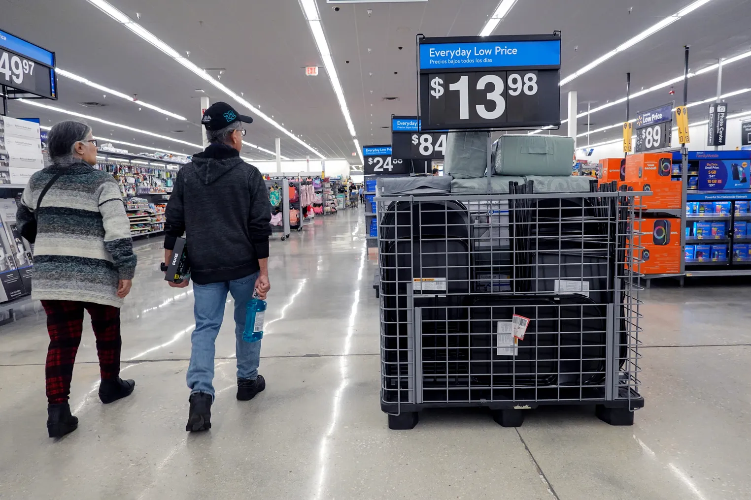 Two people walk down a store aisle past a sign that reads, "Everyday Low Price."