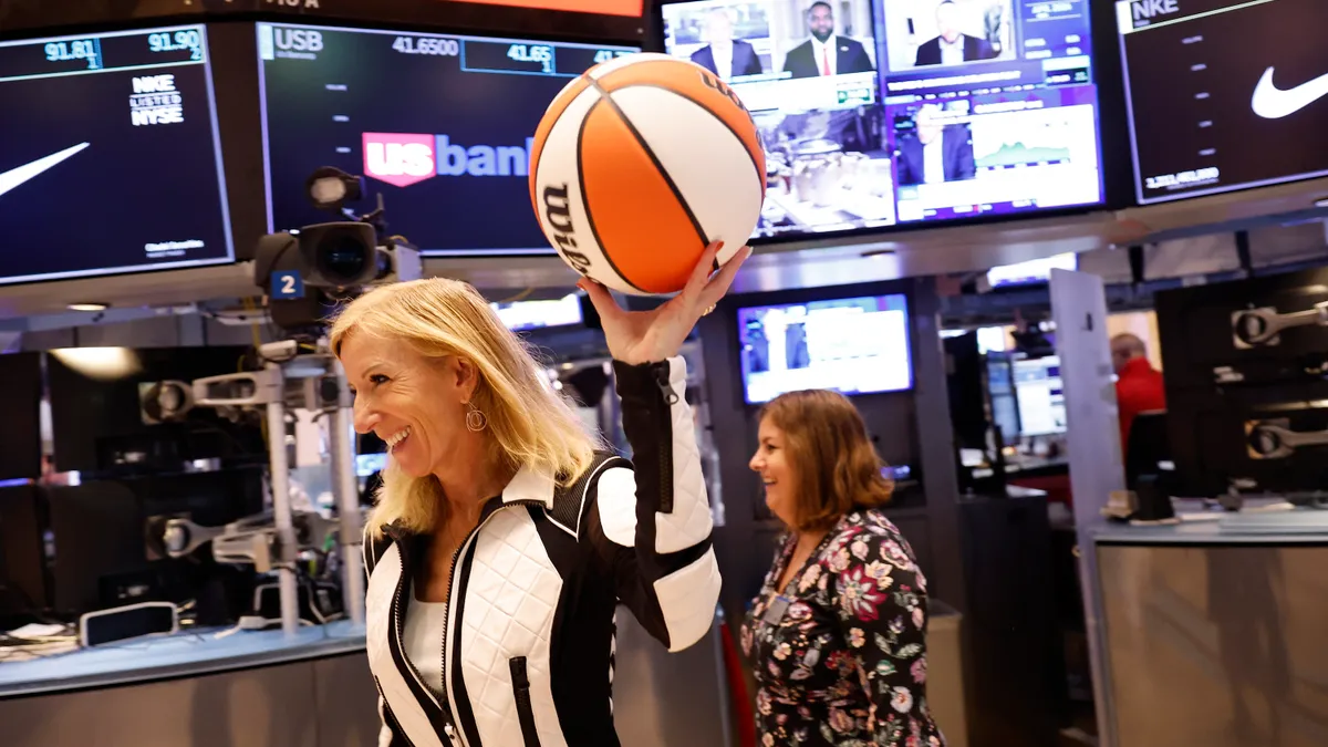 WNBA Commissioner Cathy Engelbert carries a basketball on the floor of the New York Stock exchange