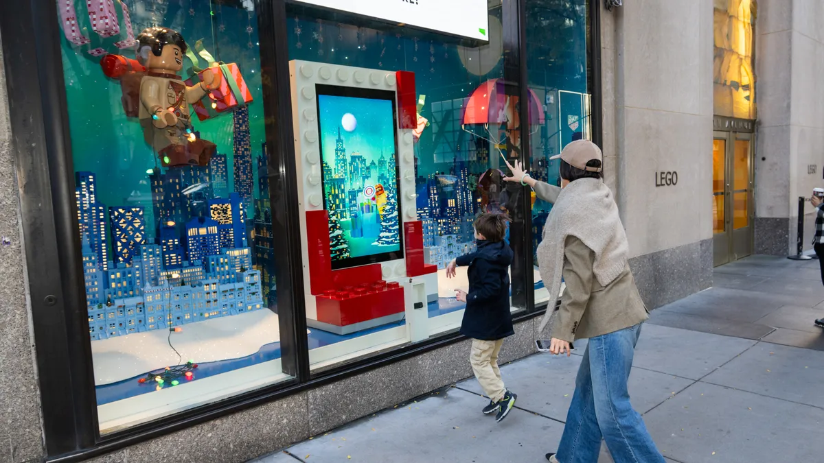 A person outside a Lego store throwing a digitized snowball as part of Lego's AR-powered "Snow Throw" activation.